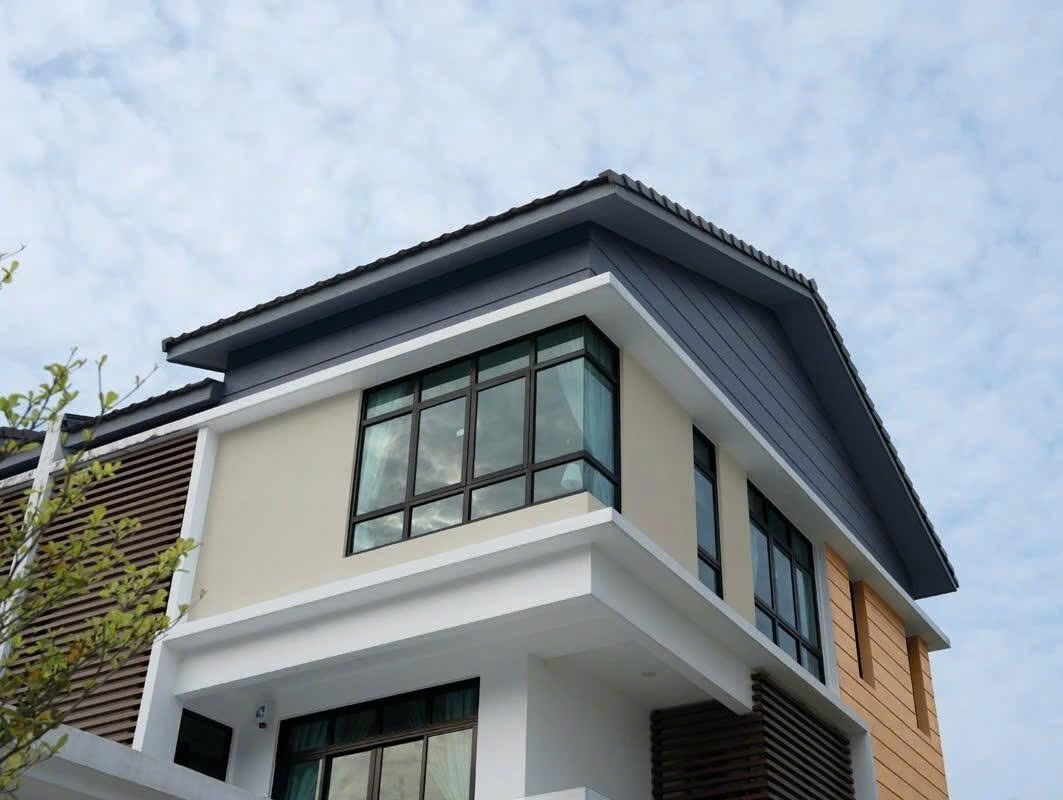 Nhà phố góc với mảng tường sáng và mái sẫm